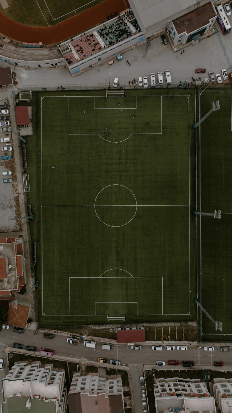 Atleti giocano a calcio su un campo circondato da una pista di atletica.