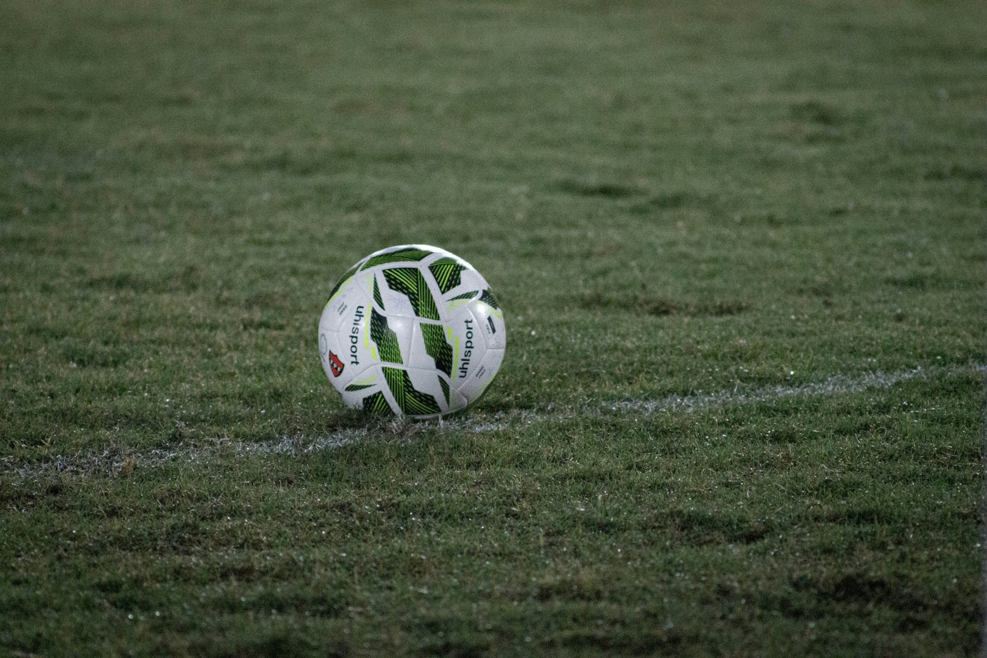 Un pallone da calcio riposa su un campo d'erba vicino a una linea di confine.